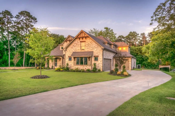 Stone-faced two-story house with dark brown roof and beige siding illustrating exterior home remodeling ideas