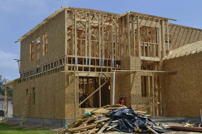 Two-story house under construction with exposed wooden framing and osb sheathing illustrating house foundation types including crawl space