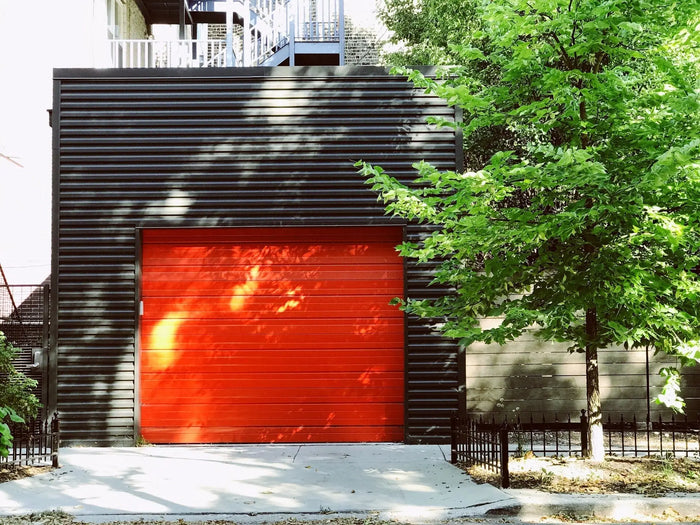 A vibrant red garage door with horizontal wood grain panels illustrating common garage remodel site plan errors.