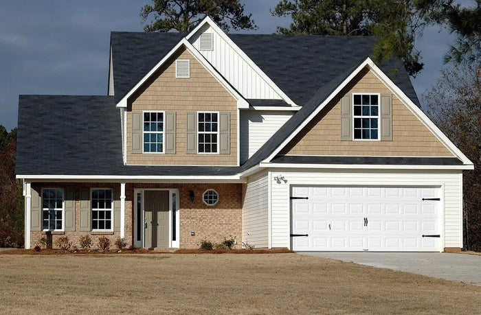 Two-toned suburban home with beige siding white trim and dark gray roof illustrating site plan and square foot costs in united states