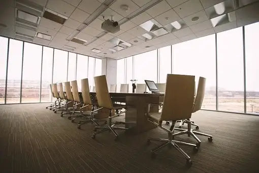 Long wooden conference table with polished surface designed for socially distant office space promoting social distancing.