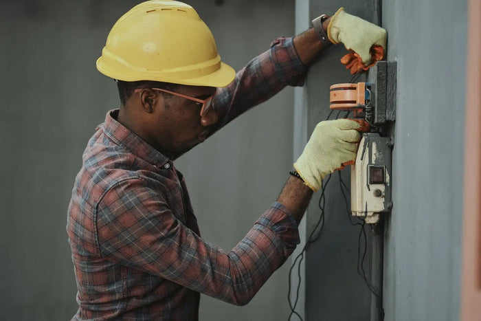 Yellow hard hat symbolizing safety gear for electrical work and electrician cost in a homeowner pricing guide article