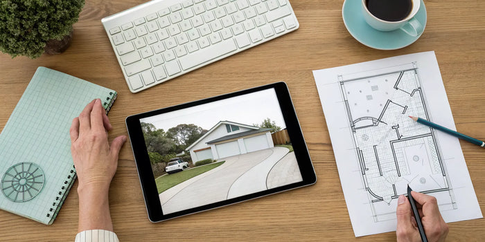 A person at a desk uses a tablet to get a driveway site plan online.
