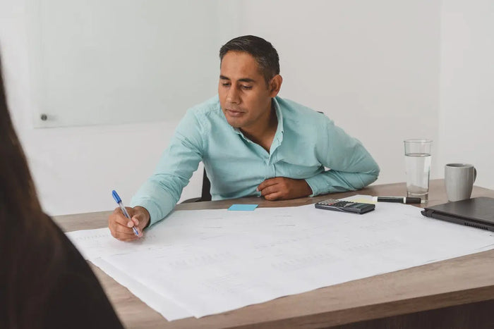 Man in light blue button-down shirt sitting at desk illustrating home inspection cost and home inspector expectations