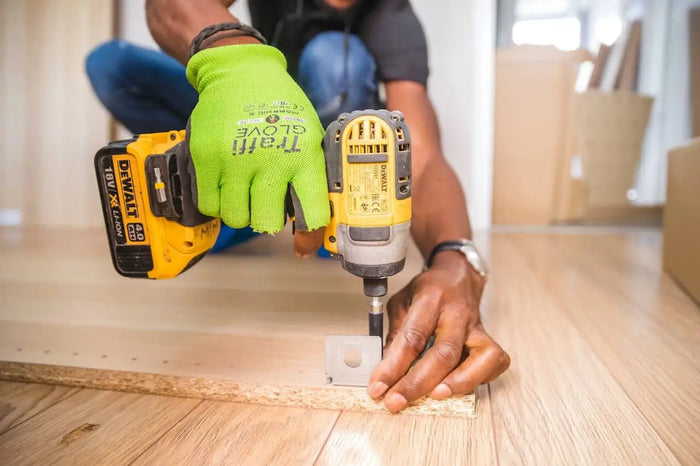Yellow and black dewalt cordless drill in use highlighting total cost and unexpected costs per square foot in house building