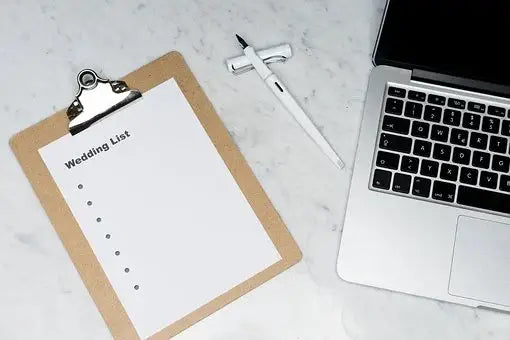 A silver laptop with black keyboard displaying a floor plan for organizing the guest list and head table at a wedding.