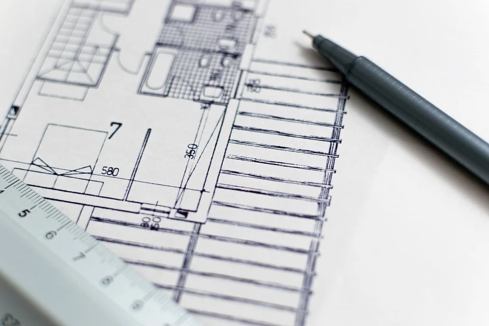 Close-up photograph of an architectural section view drawing, with a pen and ruler