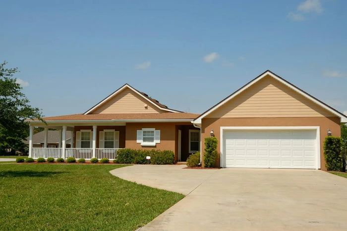 Beige siding with white trim and garage door on a modular home illustrating key features of manufactured homes.