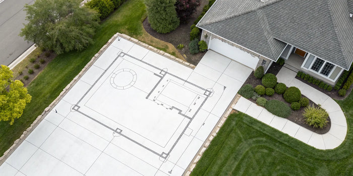 A residential plot plan example drawn on a driveway next to a house and landscaped yard.