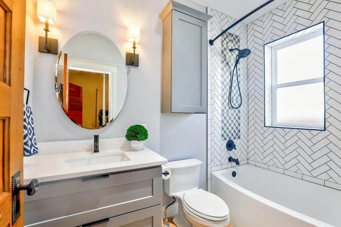 Gray vanity with white countertop and oval mirror above in septic tank site plan and drain field installation article
