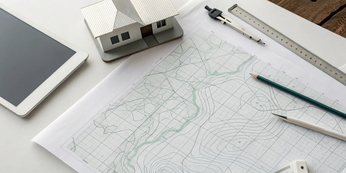 A topography site plan with contour lines and a house model for a new construction site.