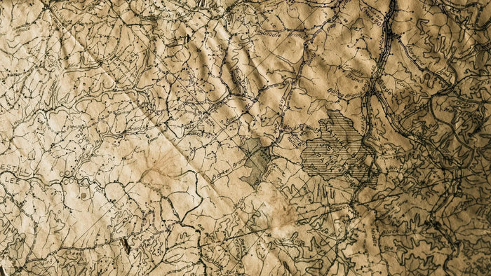 A weathered sepia-toned paper topographic map with intricate black contour lines used in site planning.