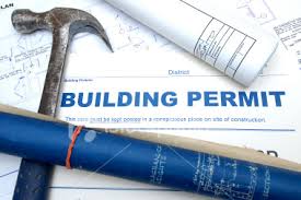 Red fountain pen with gold nib resting on a construction permit application form for building permit site plan and permit drawings